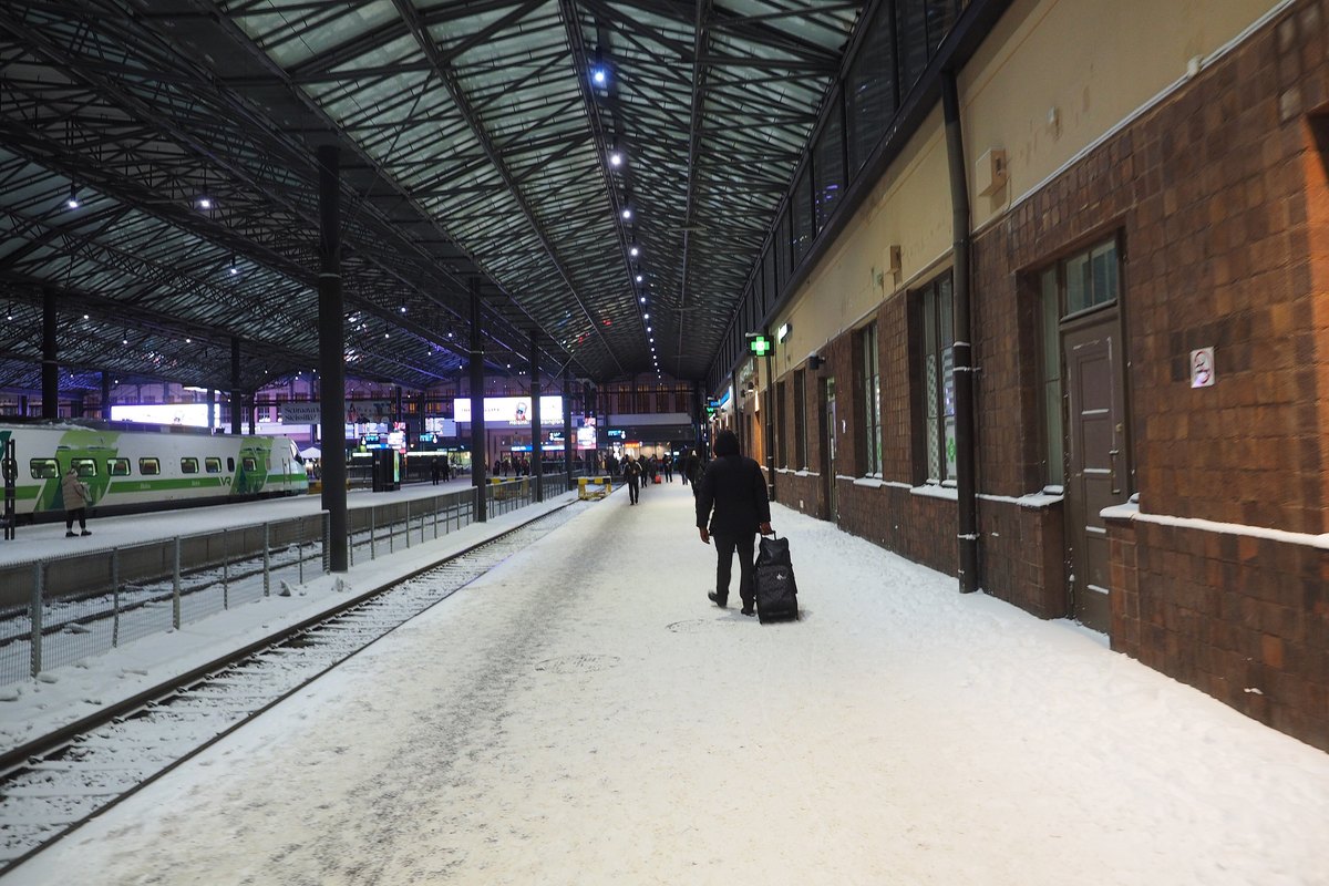 A traveller with luggage on a European railway station platform in winter